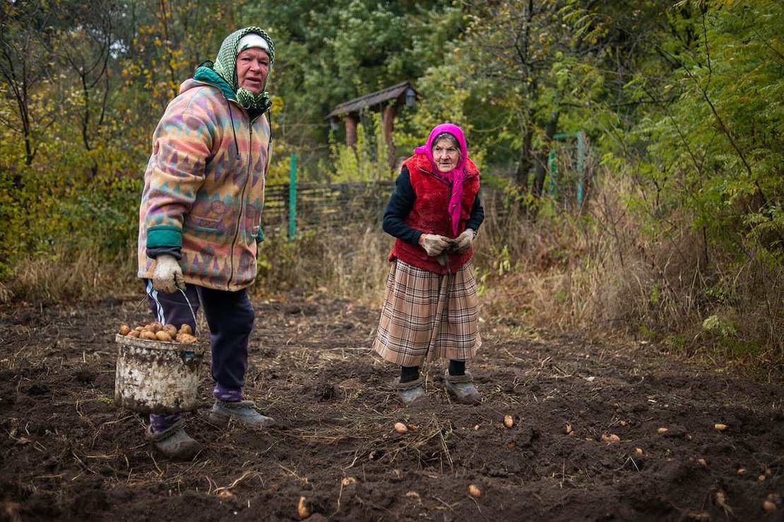 Two elderly women collect potatoes, together with four members of their extended family. They rarely hire anyone for the fields - instead members of the family rotate between themselves when they have the need to work. Riscova village