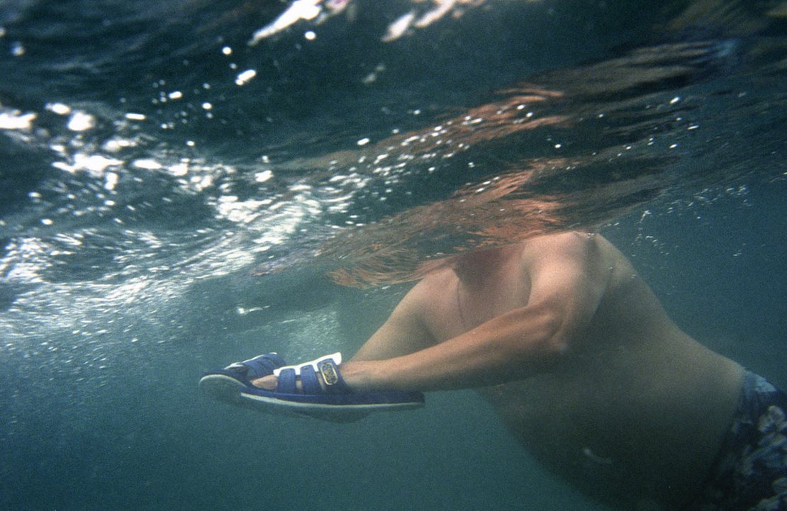 Underwater scene; a man is using his flip-flops to swim better, Pitsunda